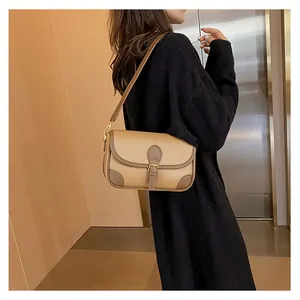 Detail view of khaki and brown patchwork leather underarm bag with metal buckle closure
