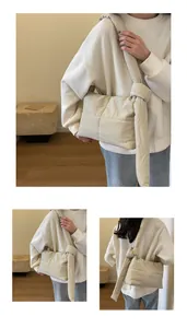 Close-up of beige quilted cloud bag with padded stitch detail and oversized strap knot