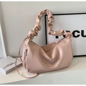Detail view of pink scrunchie handle shoulder bag with textured faux leather finish