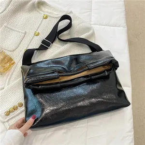 Große schwarze Handtasche aus Ölwachsleder mit glänzender Faltenstruktur und Gurt