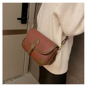Detail of vintage brick red saddle bag featuring lychee texture leather and gold hardware
