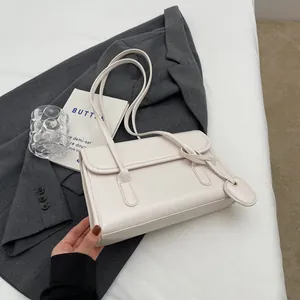 Minimalist cream white leather flap shoulder bag with dual slim straps on grey blazer