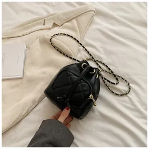 Détail de la poche matelassée en cœur et du zip doré sur un sac seau noir