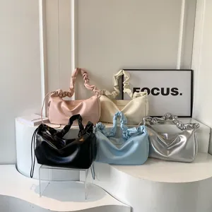 Set of minimalist ruched handle cloud bags in five colors on geometric display stands