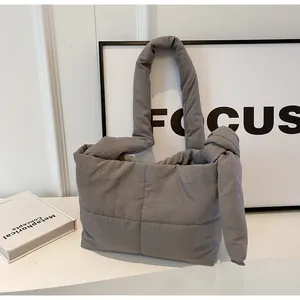 Detail of the grey quilted puffer tote bag with large square stitching and knotted shoulder strap