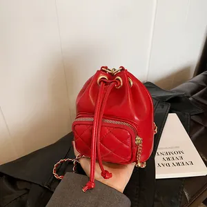 Petit sac seau rouge matelassé avec bandoulière chaîne dorée et fermeture à cordon