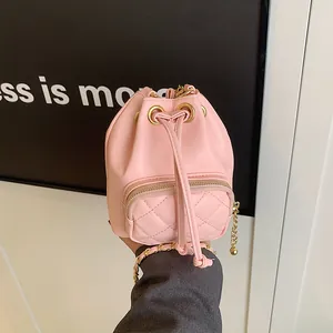 Sac seau rose en cuir matelassé avec bandoulière chaîne dorée et cordon de serrage