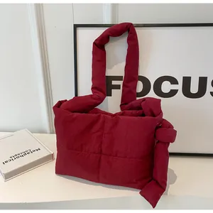Detail view of burgundy quilted tote bag with soft padded texture and stylish knotted strap