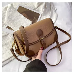 Detail of vintage two-tone brown shoulder bag with pebble grain texture and metal buckle