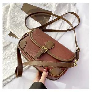 Detailed macro view of vintage brown leather texture and gold buckle of the shoulder bag