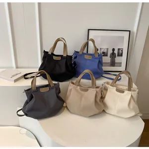 Detail view of colorful large canvas tote bags with leather handles and crossbody straps