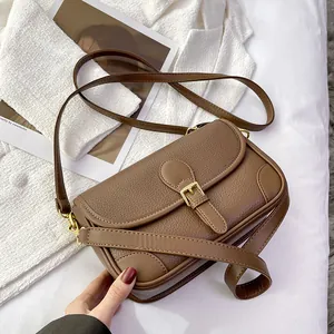 Vintage brown leather underarm bag with gold buckle and adjustable strap shown at 45-degree angle