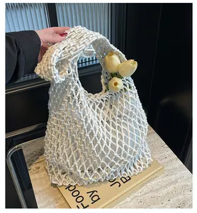 Detail of white cotton rope woven tote bag with hollow mesh design and tulips inside