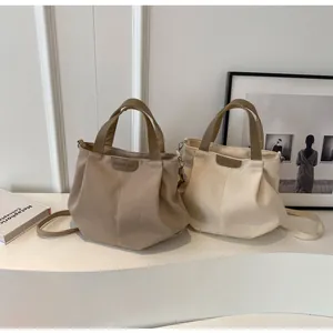 Close-up of minimalist canvas tote bags in khaki and beige with leather brand label