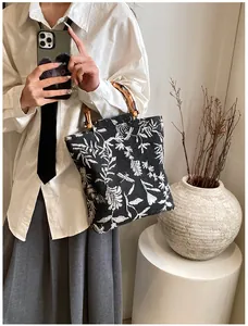 Detail of jacquard canvas tote with dragonfly patterns and natural bamboo handles