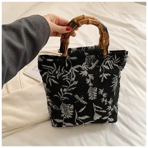 Detailed shot of vintage jacquard canvas bag with floral patterns and bamboo handle