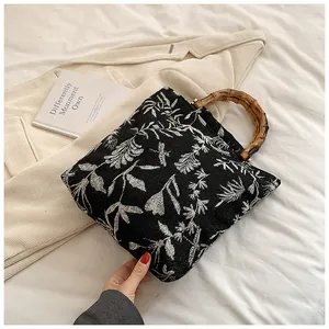 Detail of vintage leaf pattern fabric and natural bamboo handle on this chic tote bag