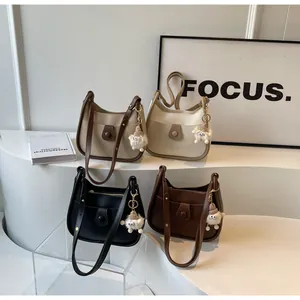 Detail view of four semi-circle saddle bags in various colors with cute plush pendants