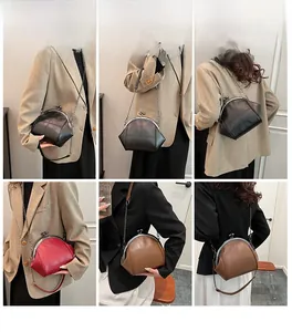 Dettaglio borsa a tracolla vintage con cuciture a croce e catena in nero e marrone