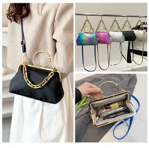 Macro detail of compact interior storage and metallic ring handle on chain evening bag