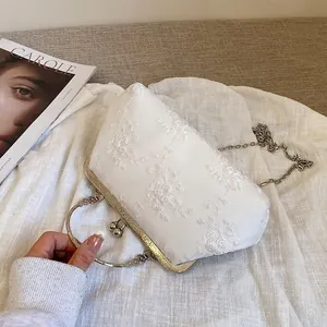 Elegante borsa da sera in pizzo bianco con ricami floreali e manico in metallo