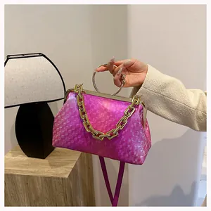 Detail of rose pink gradient handbag with gold circular handle and chunky chain strap