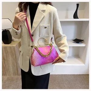 Detail of pink gradient crossbody bag with gold chain and circular handle on model