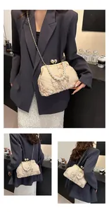 Close-up of vintage beige lace clutch with 3D floral embroidery and pearl handle detail