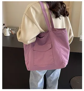 Detailed back view of a soft purple nylon tote bag worn by a model in a cozy interior