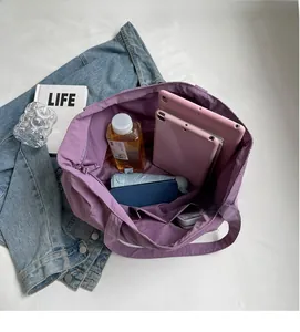Spacious interior of purple nylon tote bag showing compartments and daily essentials