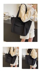 Detail view of large black nylon tote bag featuring a front flap pocket for daily commuting
