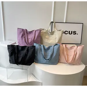 Detailed close-up of nylon tote bags in purple, beige, black, blue and pink colors