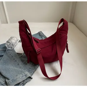 Vue détaillée du sac demi-lune en nylon oxford bordeaux avec bandoulière large et cordes