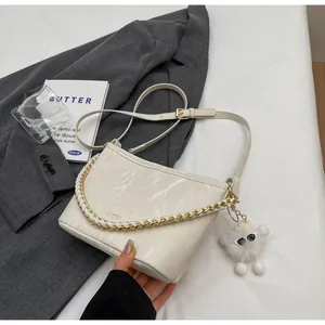 Detail van de witte marmeren emmertas met gouden ketting en pluche pop hanger