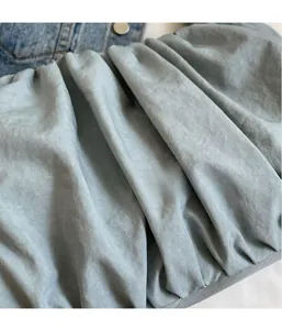 Detailed view of the light blue pleated cloud bag showing soft fabric texture and ripples