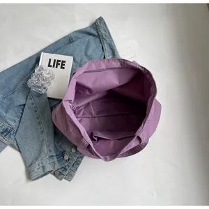Detailed view of the purple nylon tote bag interior with zipper pocket and compartments