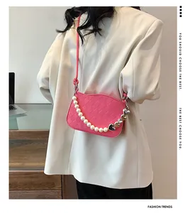 Sac bandoulière rose matelassé avec une poignée décorative en perles et cœurs argentés