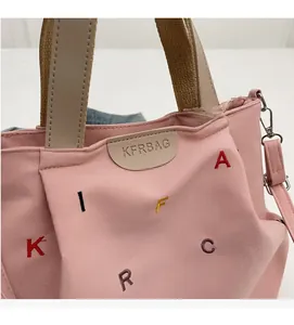 Detail of pink canvas tote showing colorful letter embroidery and KFRBAG leather patch