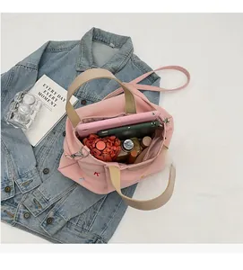 Spacious interior of a pink canvas tote bag filled with a tablet, umbrella, and cosmetics