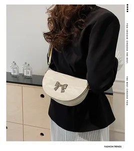 Sac demi-lune crème minimaliste avec détail noeud argenté et texture plissée