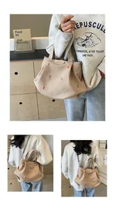 Detail of canvas tote bag with colorful letter embroidery and adjustable shoulder straps