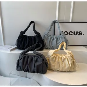 Detail of multi-color pleated tote bags with adjustable drawstring and wide strap