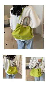 Detail view of avocado green canvas tote with colorful embroidery and leather trim