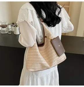 Detail of straw woven tote with brown leather trim and detachable small zip pouch