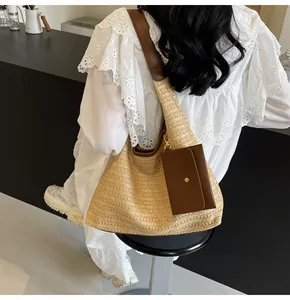 Detail of large straw tote bag with brown leather trim and mini pouch for summer
