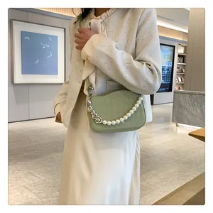 Détail du sac matelassé vert clair avec bord ondulé et bandoulière en perles chic
