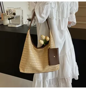 Detail of straw woven tote bag with brown leather straps and small coin purse attachment