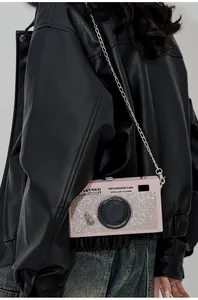 Dettaglio borsa a tracolla rosa a forma di fotocamera con cristalli e catena