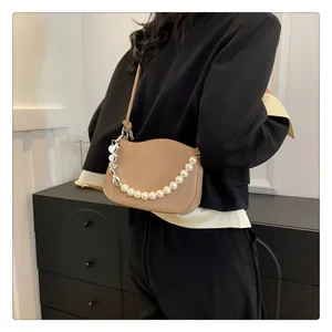 Détail du sac matelassé kaki avec chaîne en perles et pendentif coeur argenté