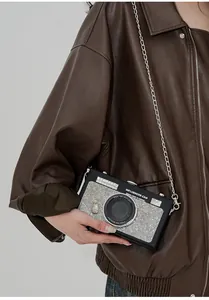 Dettaglio della borsa a tracolla creativa a forma di fotocamera con strass e catena argento